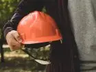 Odzież ochronna s BHP - mężczyzna trzymający kask ochronny pod pachą