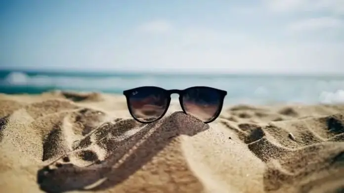 Wczasy pod gruszą - okulary położone na pisaku na plaży