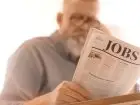 Mężczyzna czytajacy gazetę z napisem "jobs"