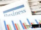Gazeta z napisem "bizness" i wykresami