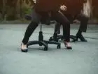 Pracownicy uciekający ulicą na krzesłach biurowych