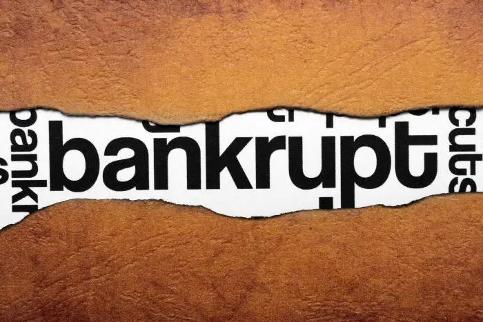 Napis "bankrupt" umieszczony na grafice na brązowym tle