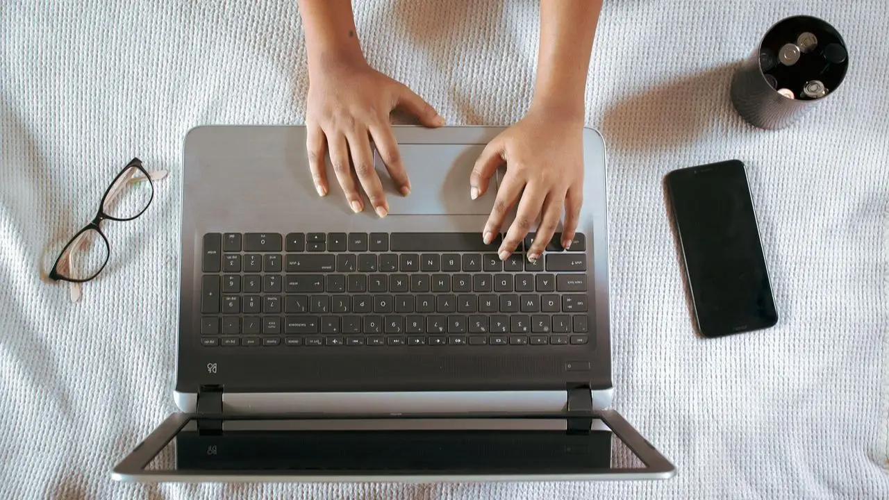 Zalany laptop - dłonie na klawiaturze laptopa