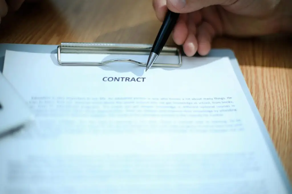 Czy umowa kontraktowa zastąpi umowę o pracę - dłoń wskazująca na dokumencie napis contract