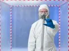 Mężczyzna w kombinezonie oglądający materiał badawczy