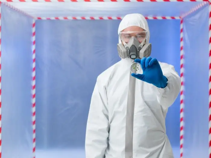 Mężczyzna w kombinezonie oglądający materiał badawczy