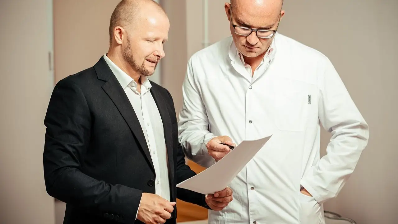 L4 od psychiatry - lekarz tłumacżacy coś pacjentowi na dokumencie