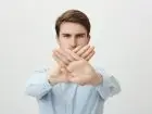 Odmowa świadczenia pracy zdalnej - mężczyzna trzymający skrzyżowane dłonie w ramach odmowy