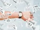 Okres rozliczeniowy - dłoń z zegarkiem, wokół rozrzucone kartki z napisem "time"