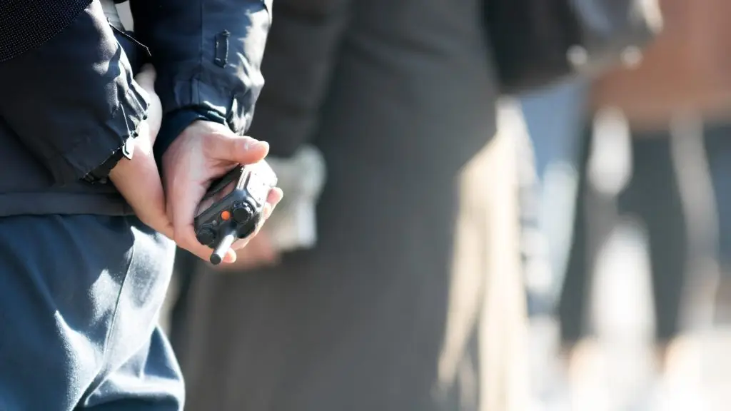 500 plus dla policjantów - osoba w mundurze trzymająca krótkofalówkę