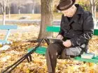 Emeryt na ławce w parku w jesieni