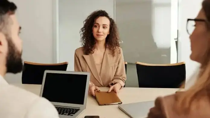 Jak odwołać rozmowę kwalifikacyjną - kobieta siedząca przy biurku podczas rozmowy rekrutacyjnej