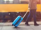 Koronowirus przyczyną ucieczki pracowników - osoba idąca wzdłuż peronu z walizką