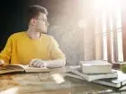 Student podczas odrabiania lekcji lub nauki, w żółtym swetrze