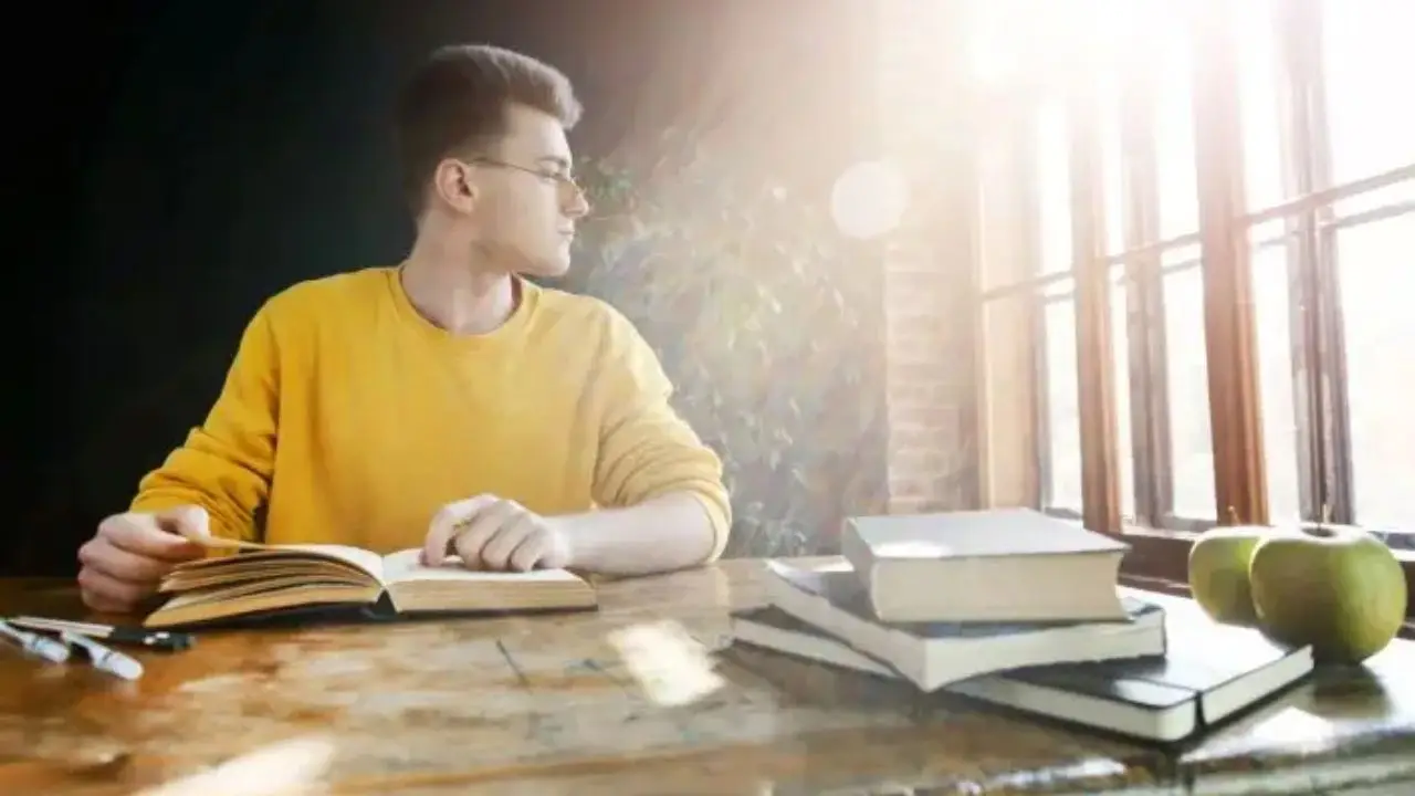 Student podczas odrabiania lekcji lub nauki, w żółtym swetrze