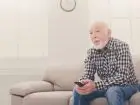 Emeryt siedzący na kanapie