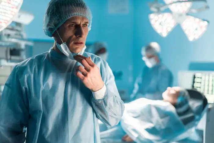 Lekarz odsłaniający maseczkę w sali operacyjnej