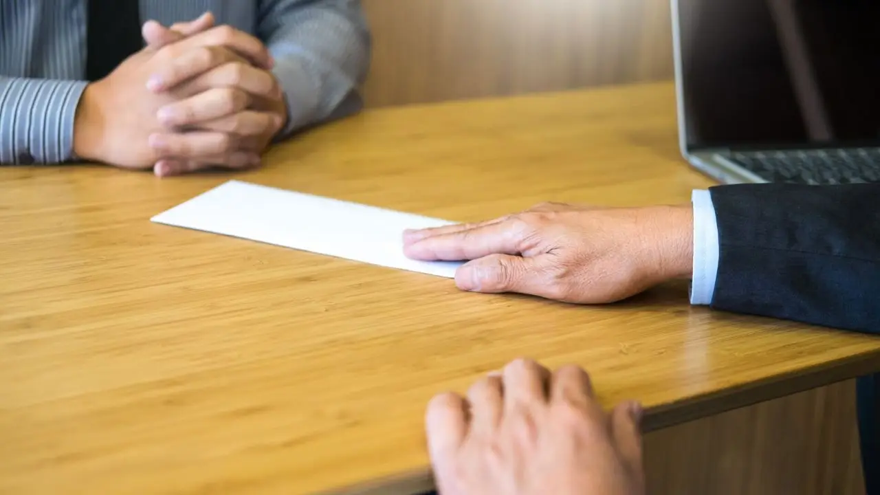 PPK a zmiana pracy - pracownik wręczający wypowiedzenie pracodawcy przy biurku