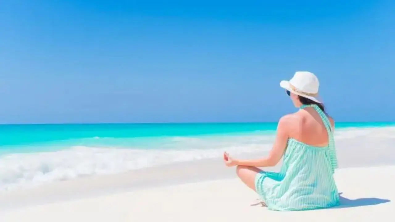 Urlop sabbatical - kobieta medytująca na plaży