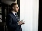 Przedsiębiorca z filiżanką kawy przy oknie