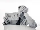 Mężczyzna trzymający kartkę z napisem help