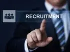 Mężczyzna w garniturze na tle napisu recruitment