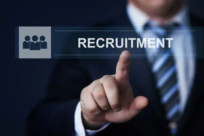 Mężczyzna w garniturze na tle napisu recruitment