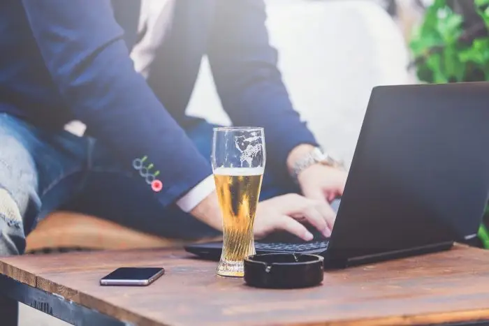 Mężczyzna pracujący przy laptopie, obok piwo