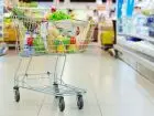 Symboliczne zdjęcie wózka zakupowego wypełnionymi produktami w przykładowym markecie