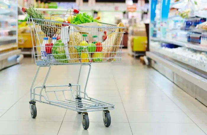 Symboliczne zdjęcie wózka zakupowego wypełnionymi produktami w przykładowym markecie