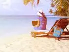 Kobieta z laptopem na leżaku na plaży