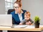 Mama w trakcie pracy przy laptopie, z dzieckiem na kolanach