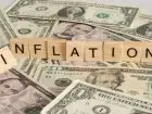 Dolary a na nich ułozony z klocków napis po angielsku inflacja