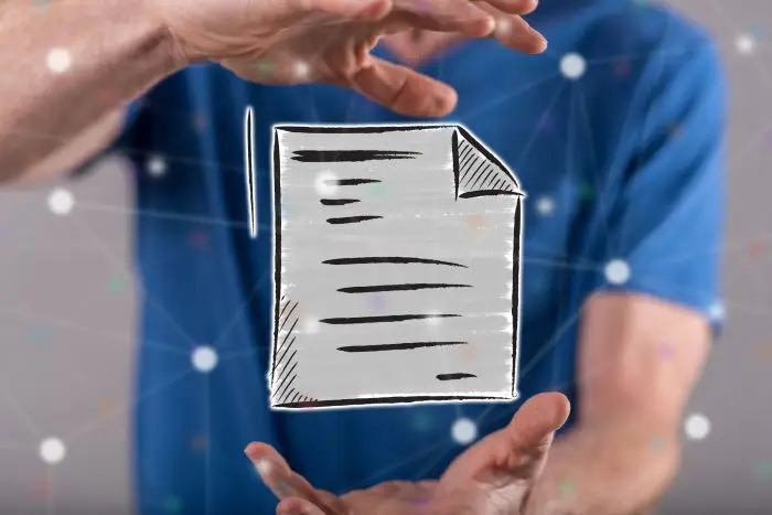 Mężczyzna trzymający w powietrzu grafikę przypominającą dokument