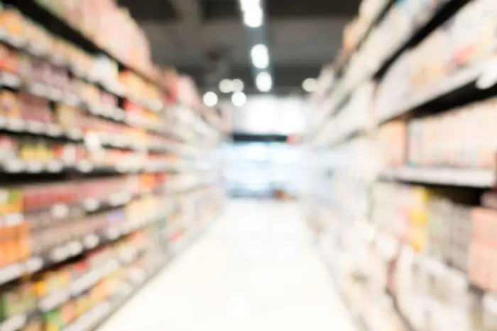 Symboliczne zdjęcie przedstawiające rozmyty widok wnętrza supermarketu