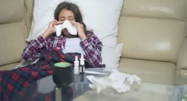 Kobieta w trakcie choroby na kanapie