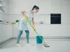 Kobieta myjąca podłogę w kuchni