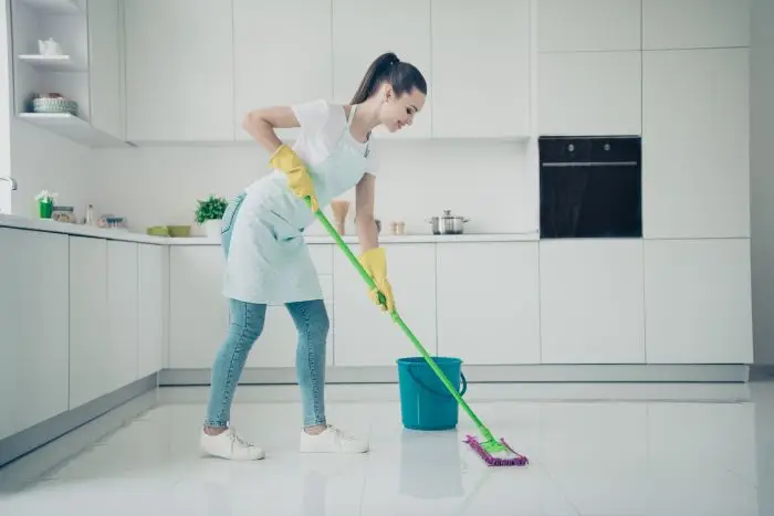 Kobieta myjąca podłogę w kuchni