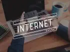 Napis internet na tle laptopa używanego przez mężczyznę