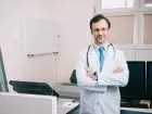 Umowa zlecenie - badania lekarskie - lekarz w gabinecie z założonymi rękami