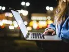 Kobieta pracująca na laptopie na dworze