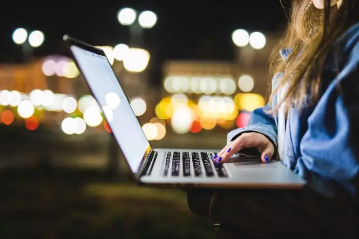 Kobieta pracująca na laptopie na dworze
