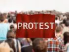Napis protest na tle idącego tłumu