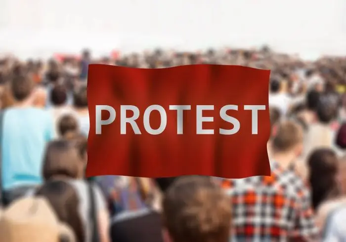 Napis protest na tle idącego tłumu