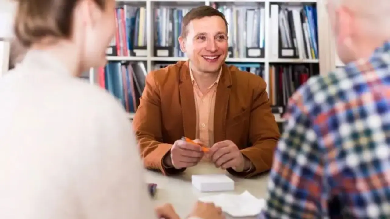 Mężczyzna siedzący przy biurku z klientami