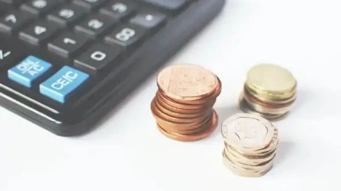 Płaca minimalna 2022 - monety i kalkulator na stole