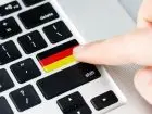 Podatek dochodowy w Niemczech - klawiatura komputera z klawiszem w barwach flagi Niemiec