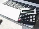 Kalkulator postawiony na laptopie