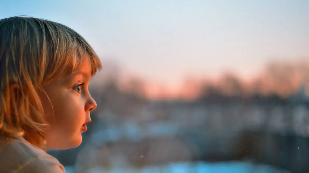 12 tysięcy na dziecko - dziecko patrzące przez okno