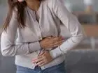 Praca a endometrioza - kobieta trzymająca się za bolesny brzuch